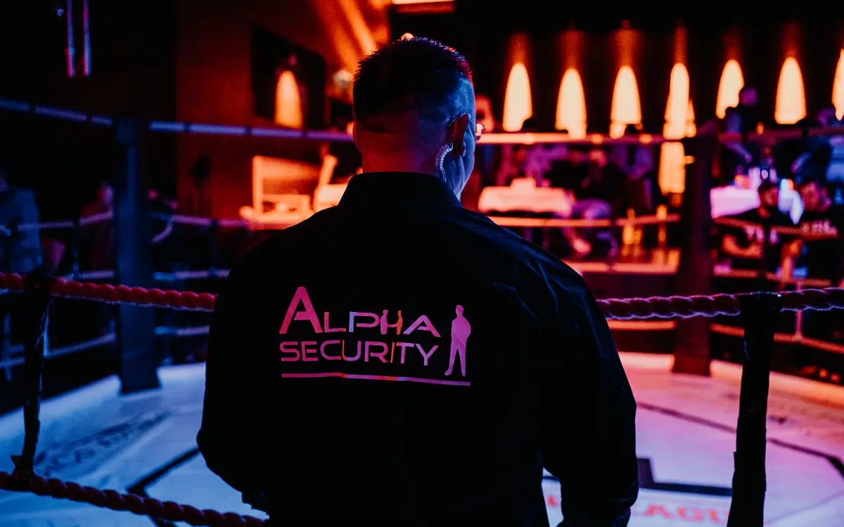 Mitarbeiter von Alpha Security am Boxring, Logo auf dem Rücken