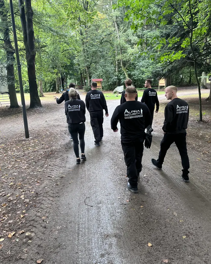 Mitarbeiter von Alpha Security gehen gemeinsam einen Waldweg entlang