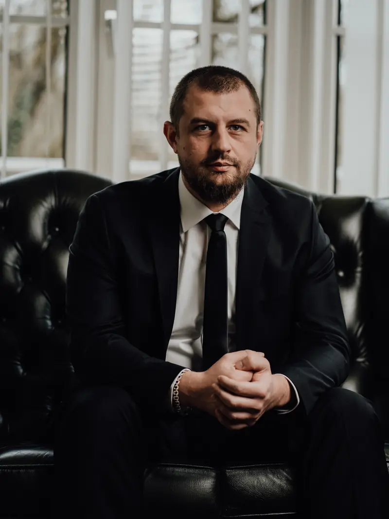 Ilja Weber im Anzug auf einem Chesterfield-Sessel